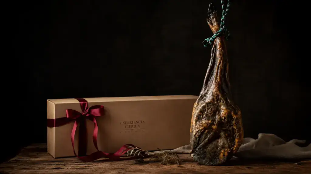 Jamón ibérico junto a una caja de regalo gourmet